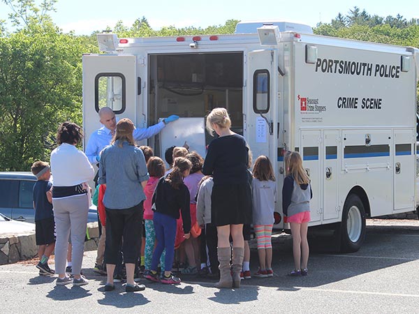 Officer showing a group of students the Police Evidence Van