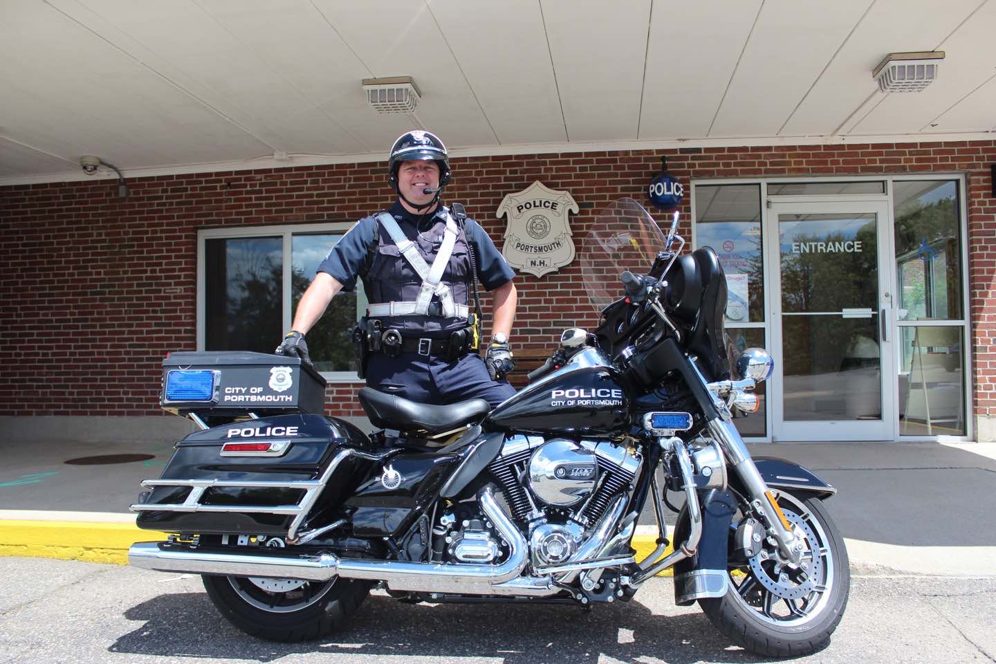 Motorcycle Police Officer with motorcycle in front of Police Station