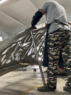 Worker fabricating the sculpture