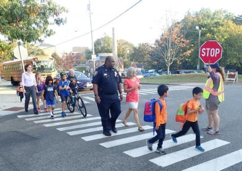 Chief Newport helps schoolchildren at crosswalk.